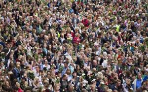 Masses of people gather to participate in a "rose march" in honour of the victims of Friday's bomb attack and shooting massacre, outside Oslo City Hall